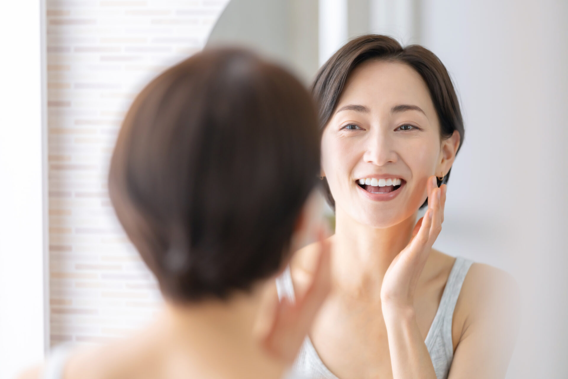 自分の顔と向き合いながらセルフケアをする女性