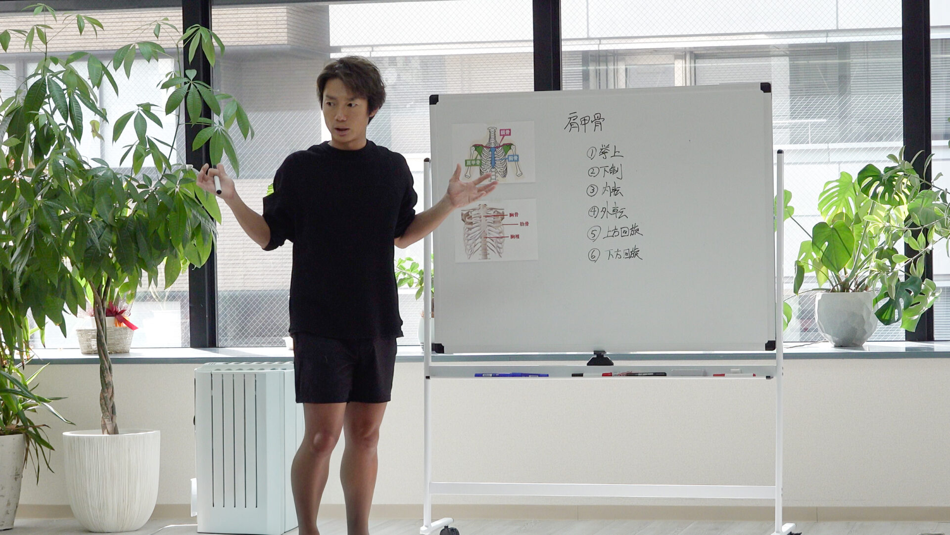 ホワイトボードを使い身体やヨガを解説するRio